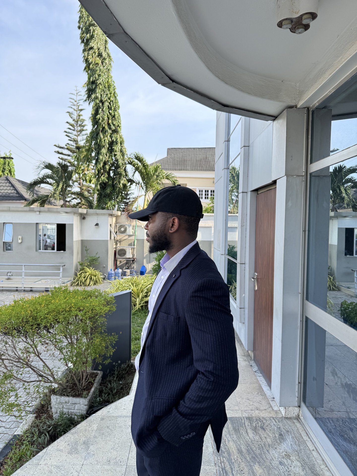 Abdulrasheed Ijaodola in a cap and pinstripe suit